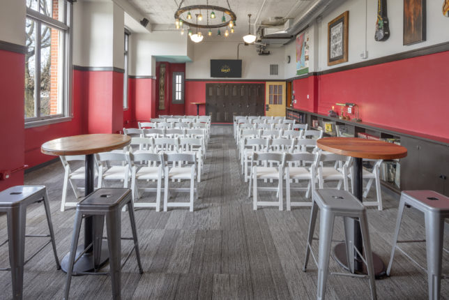 A lecture / viewing seating arrangement in The Sunset Room, with rows of chairs on either side and a walkway in the middle.