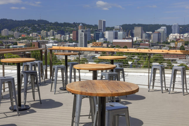 The outdoor seating on the roof deck at Revolution Hall, with the Portland skyline in the background.